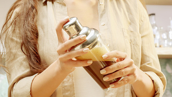 женщина встряхивает nescafé фраппе американо в шейкере женщина встряхивает nescafé фраппе американо в шейкере