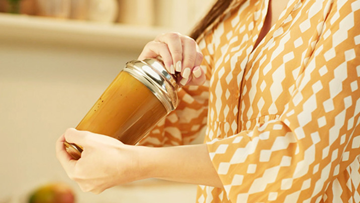 женщина встряхивает nescafé фраппе манго в шейкере