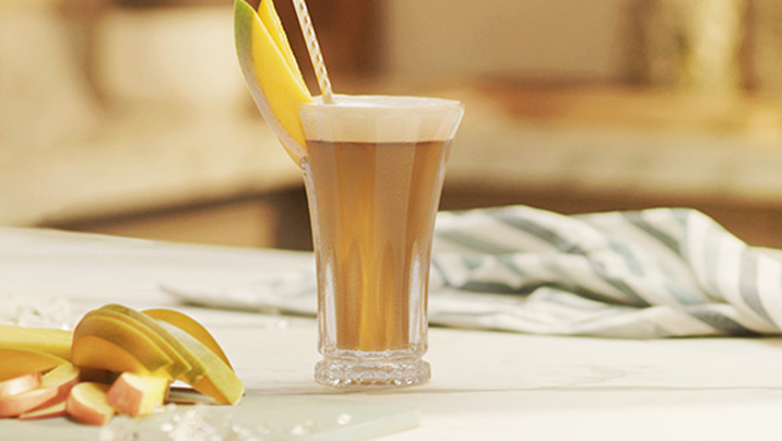 бокал с nescafé фраппе манго на столе