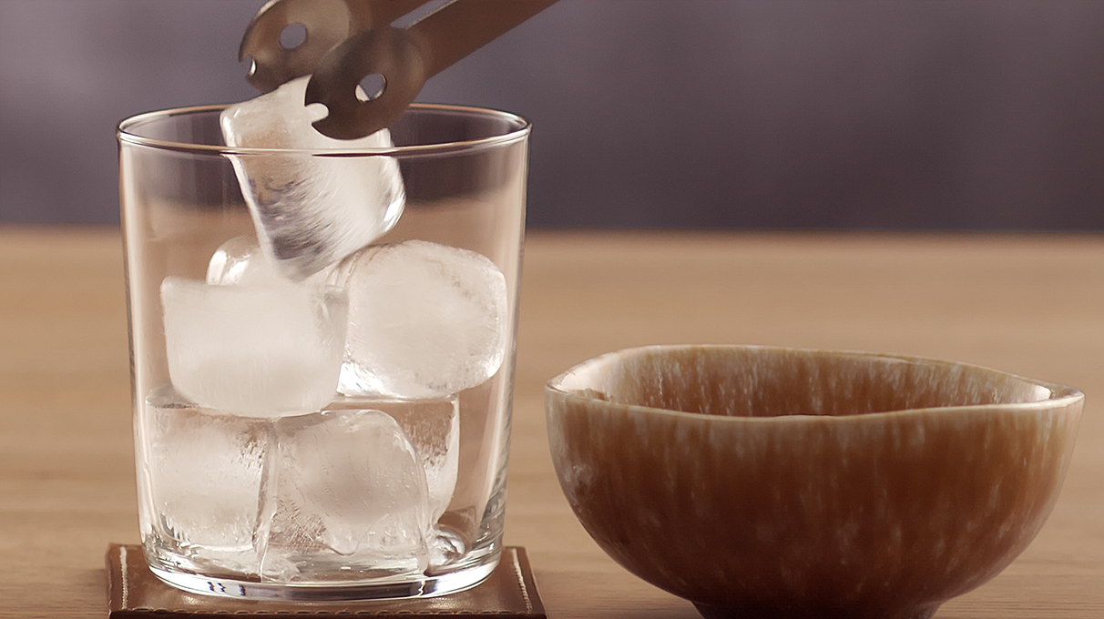 прозрачный бокал наполняется кубиками льда