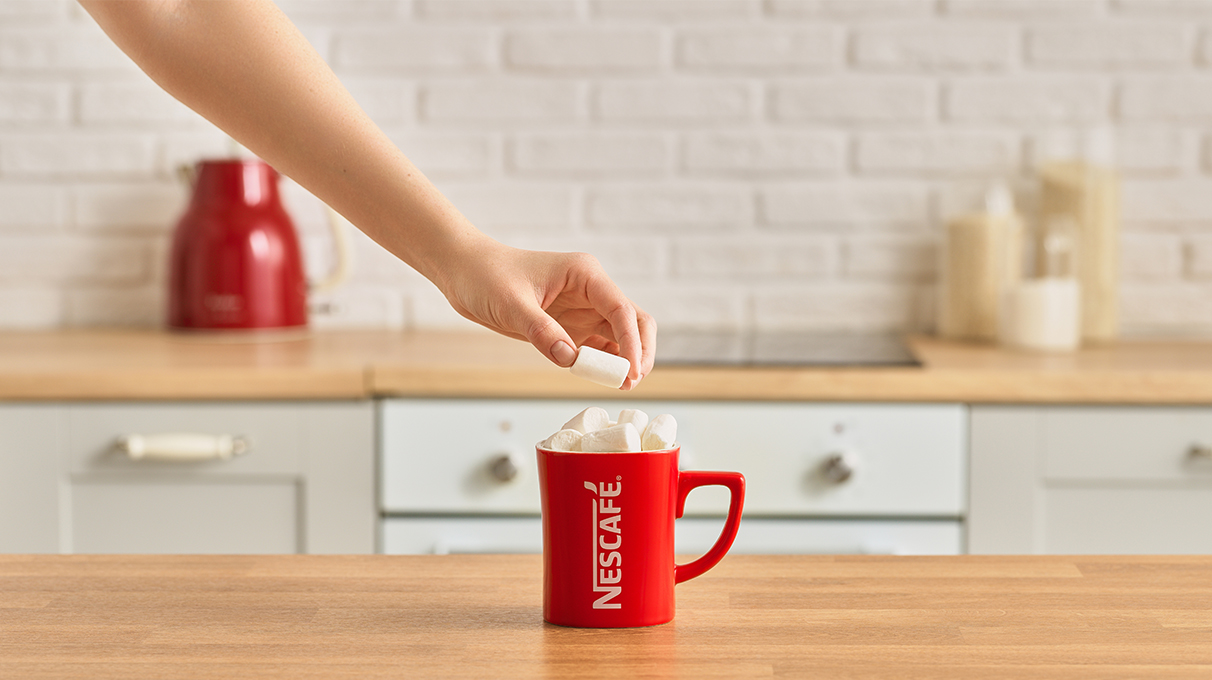 напиток в красной кружке украшается маршмеллоу напиток в красной кружке украшается маршмеллоу