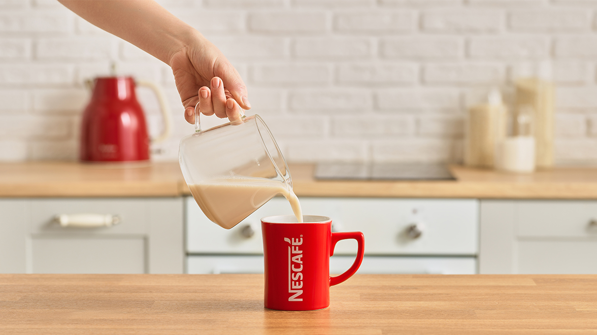 молоко наливается в красную кружку молоко наливается в красную кружку