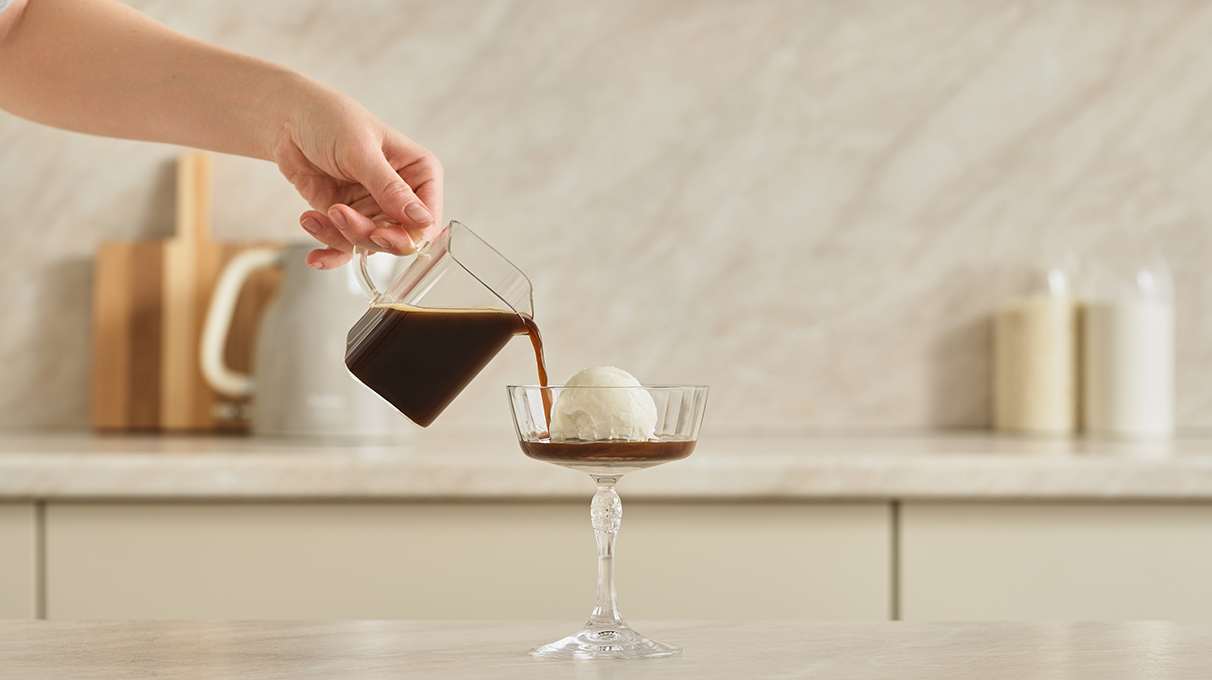 Залейте кофе горячей водой и перемешайте. Добавьте кофе к мороженому