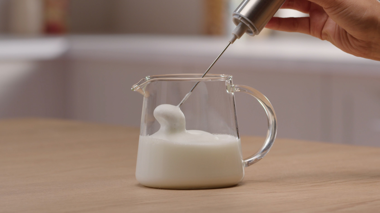 В отдельной емкости взбейте молоко до образования пенки