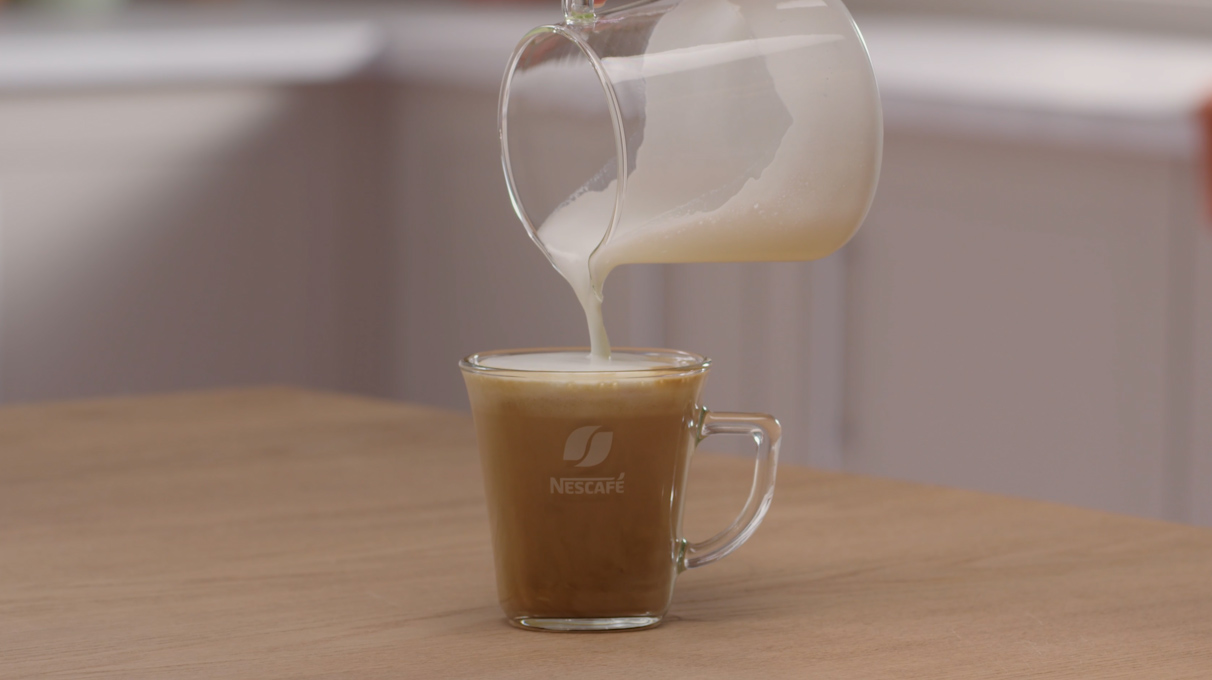 Добавьте взбитое молоко к кофе