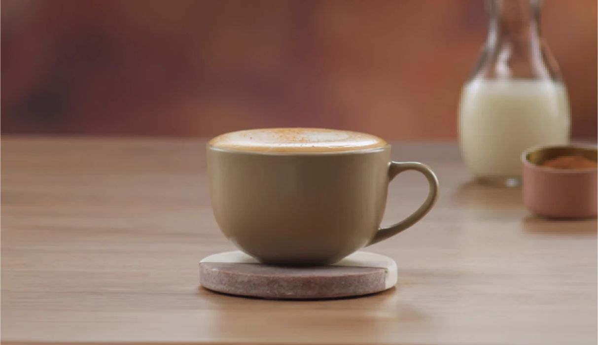 бокал с nescafé капучино на столе