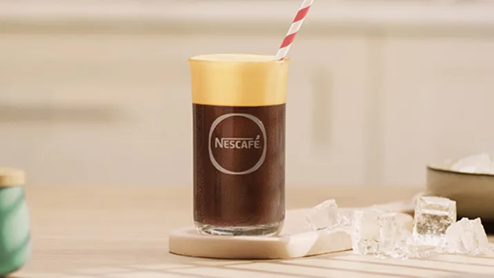 бокал с nescafé фраппе американо на столе