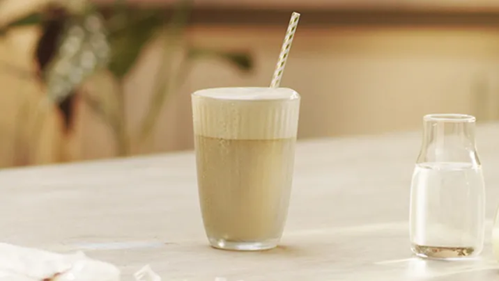 бокал с NESCAFÉ Фраппе по-Вьетнамски на столе